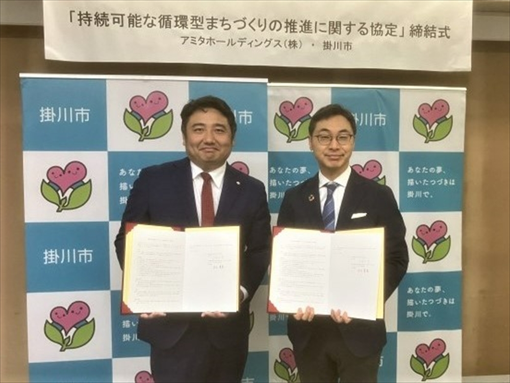 協定書を手にするアミタHDの末次貴英社長（左）と掛川市の久保田宗市長