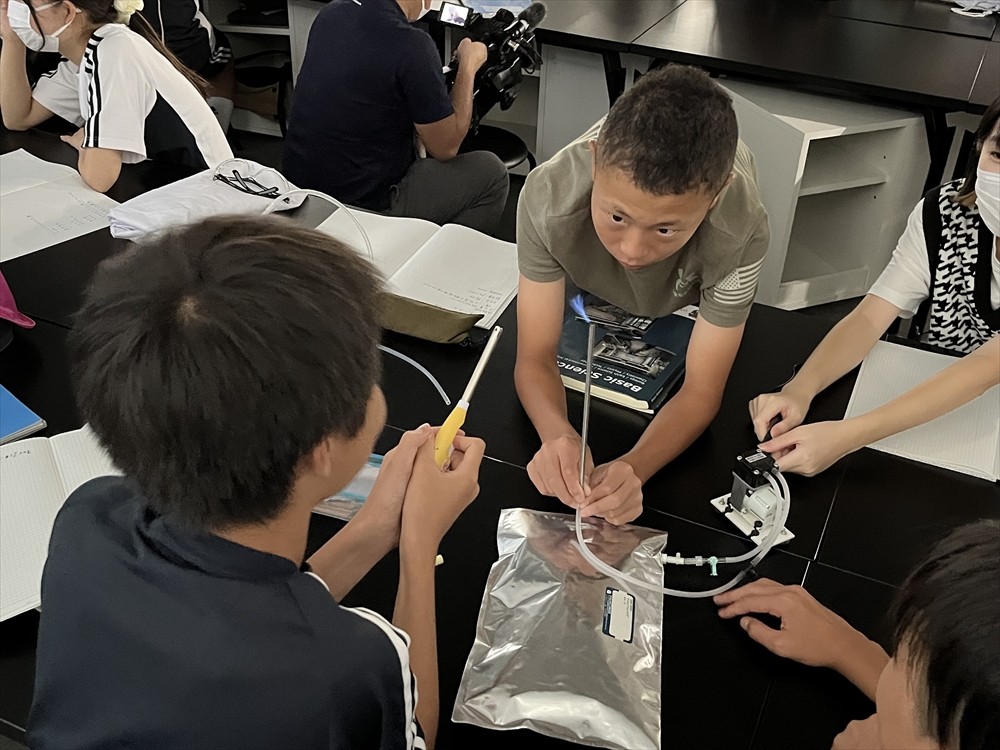 これからの環境学習は実体験交えじっくりと　ＮＴＴ東日本とビオストックなど　都内の中学生を対象に実施_メタンガスの燃焼実験。器具の取り扱いも学んだ