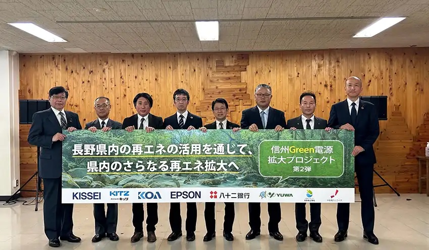 プロジェクト開始の横断幕を掲げる八十二銀・中村誠取締役（左から5人目）ら各者・社の代表（中部電力ミライズ提供）