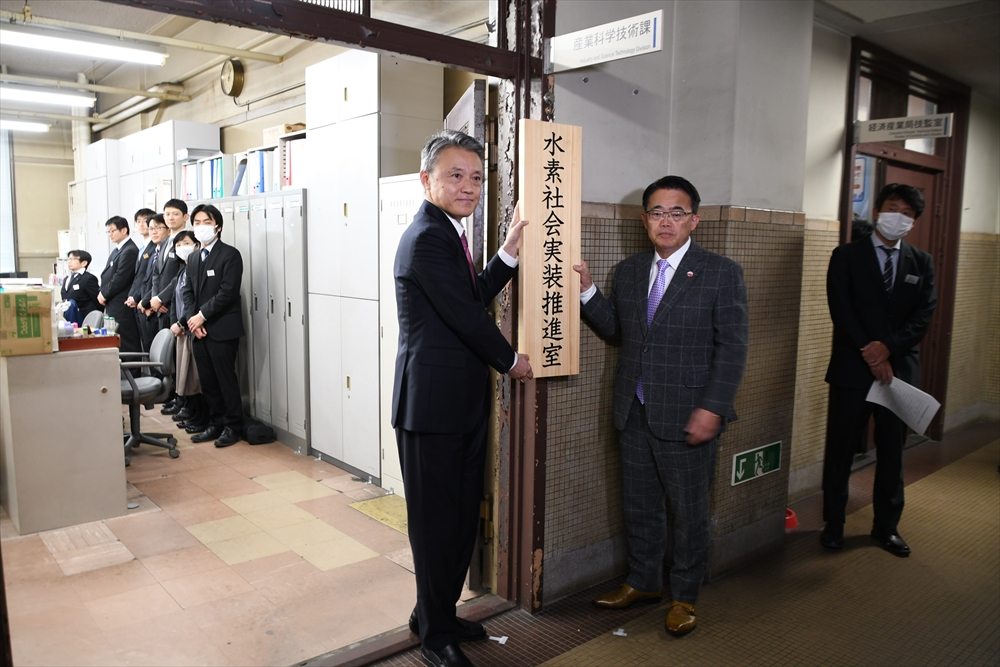 看板掛けする大村知事（右）