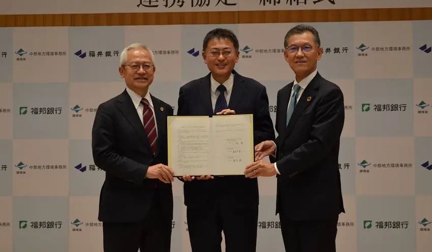 協定書を掲げる（左から）長谷川・福井銀頭取、小森・環境省中部地方環境事務所長、湯浅・福邦銀頭取（12月21日、福井銀本店）