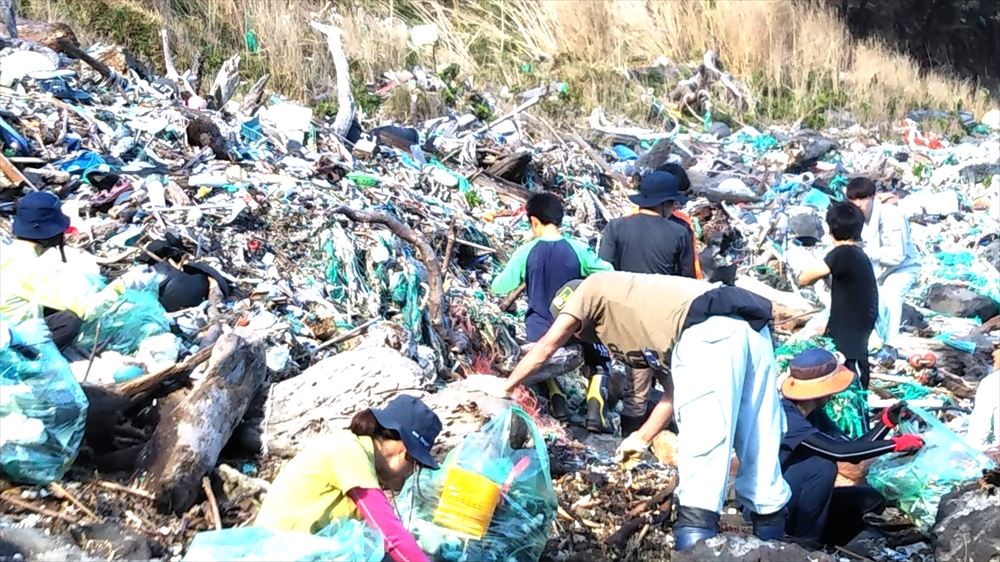 漂着ごみで埋まる西ノ浜海岸を全島民で清掃する様子