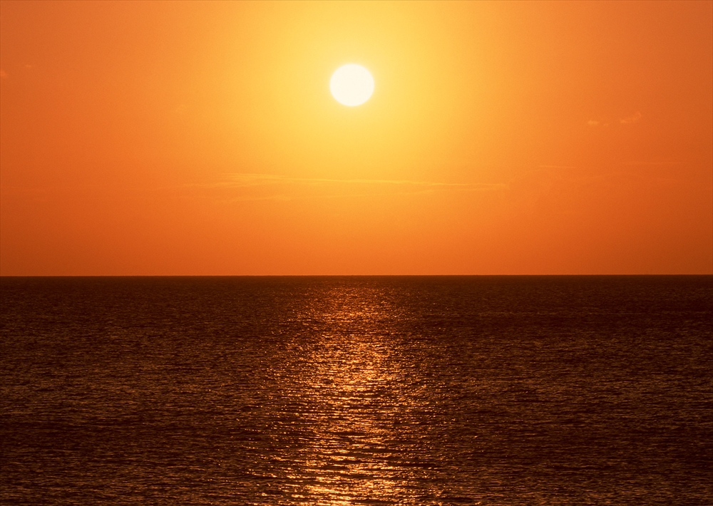 IMAGE_これは夕日の写真です。海の上に沈みゆく太陽と、その反射が美しく映し出されています。