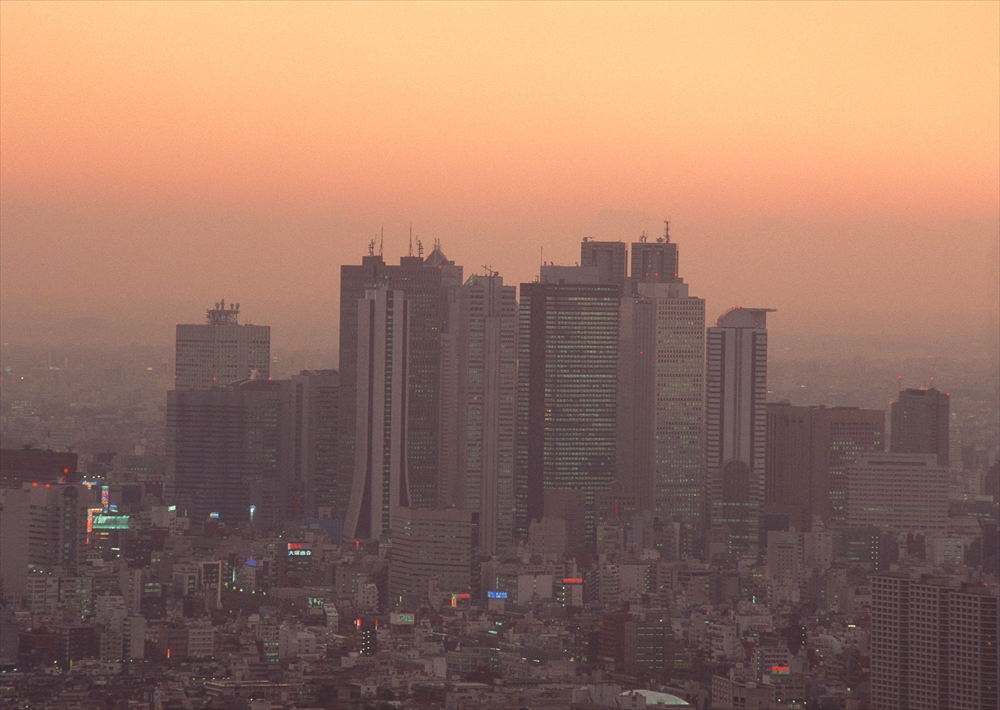 IMAGE_これは都市の風景を写した写真のようです。高層ビルが並ぶシーンで、夕焼けの空が背景にあります。具体的な場所についてはわかりません。
