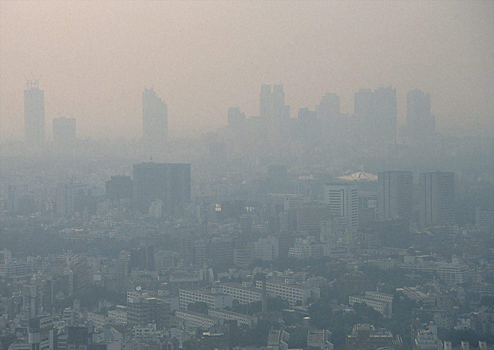 IMAGE_この写真は、都市の景観が霧や煙で覆われている様子を示しています。ほとんどの建物が薄い視界の中に見えており、空気の質が良くないことを示唆しています。具体的な場所や状況についてはわかりませんが、都市部の風景と考えられます。