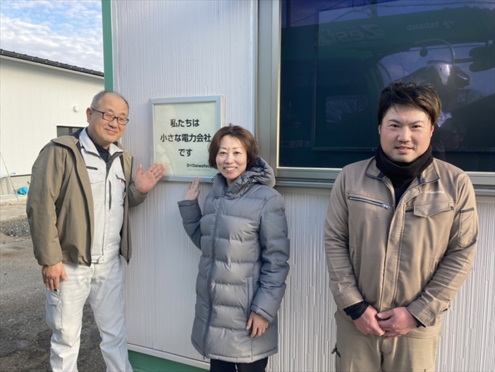 能登町の同社拠点ＳＳＨ前に立つ片桐さん（中央）。同町職員（左）や関連会社社員（右）と協力して支援に当たった。
