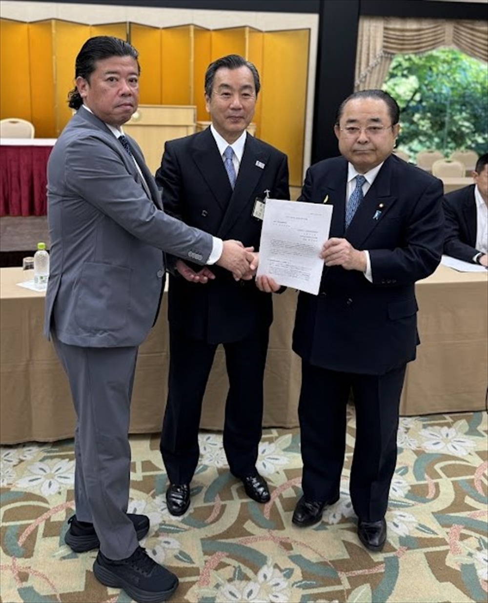 永井良一・全産連会長（中央）、藤枝慎治・全産連政治連盟理事長（左）から田中和徳・産業・資源循環議員連盟会長に要望書が手渡された