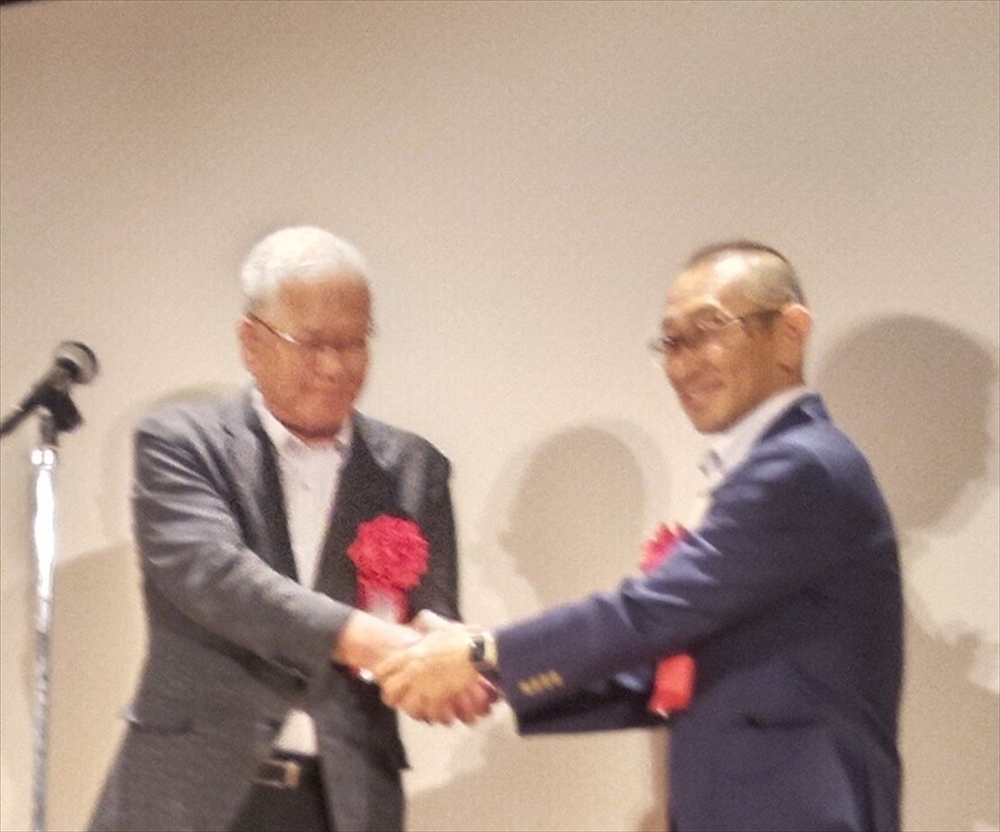 握手する八王子市（右）と箕面市の副市長