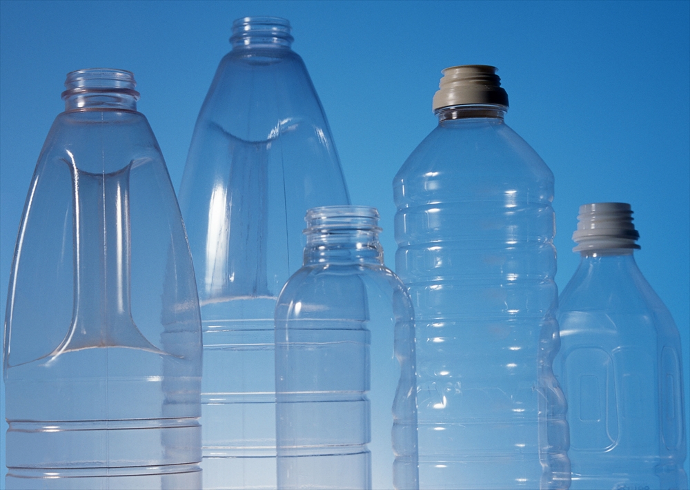IMAGE_これは透明なプラスチックボトルの写真です。様々なサイズや形状のボトルが並んでいる様子が見えます。背景は青い色合いです。ボトルは一般的に水や飲料を入れるために使われる容器です。