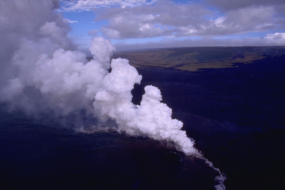 IMAGE_これは火山の噴煙や溶岩が海に流れ込んでいる様子を捉えた写真のようです。特に、溶岩と水が接触することで発生する蒸気や煙が見えます。火山活動は自然の力強さを示すものです。