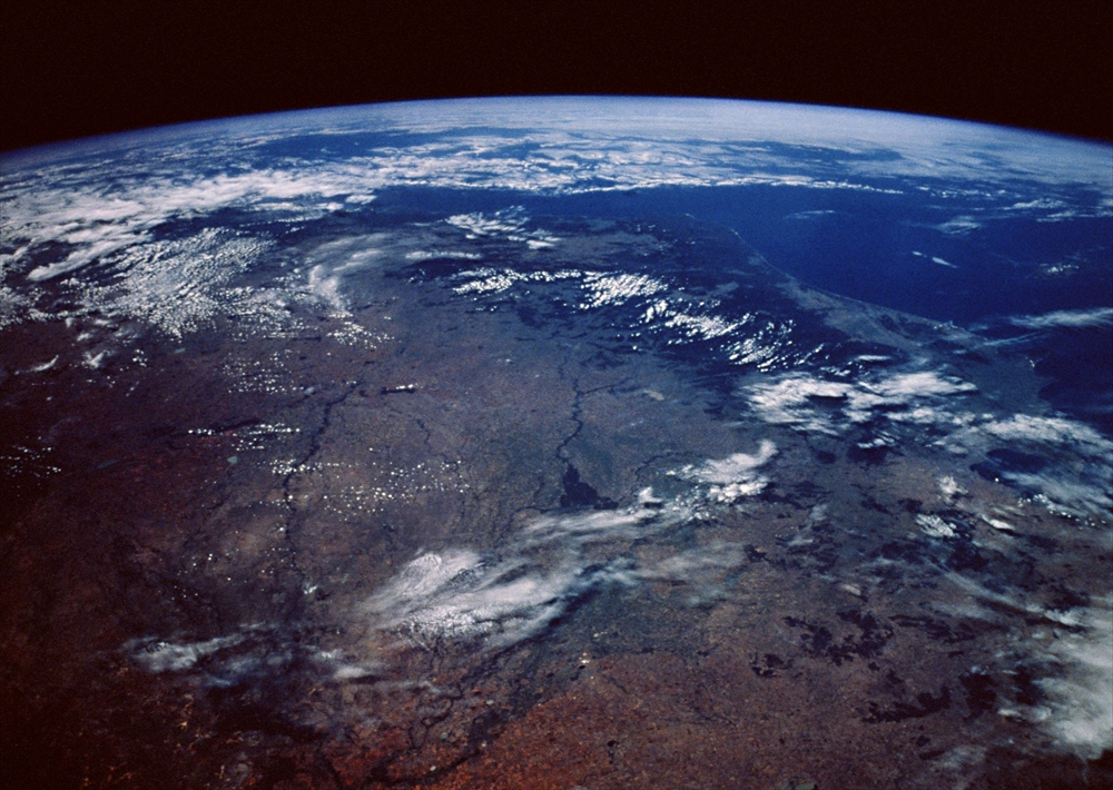 IMAGE_これは地球の上空から撮影された写真です。地表の陸地や海、雲の様子が見て取れます。このような写真は、宇宙からの視点を提供し、地球の地理的な特徴や気象現象を観察するのに役立ちます。