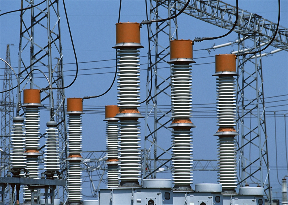 IMAGE_これは電力設備や送電線の写真のようです。特に、絶縁体や変圧器の一部が見えている可能性があります。電力の送電や配電に関連する機器が含まれています。