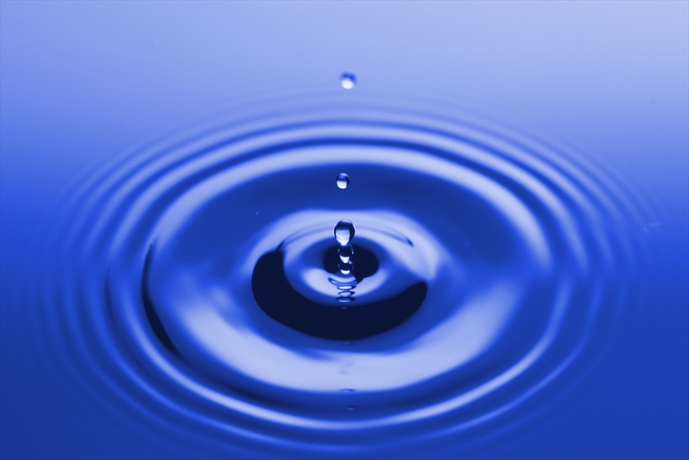 IMAGE_これは水の滴が水面に落ちた時の写真です。波紋が広がっている様子が表現されていますね。全体的に青い色調が印象的です。