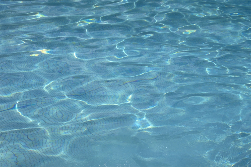 IMAGE_これは水面の写真のようです。水の波や光の反射が見られ、清らかで静かな印象を与えます。おそらくプールや湖の水面を撮影したものでしょう。