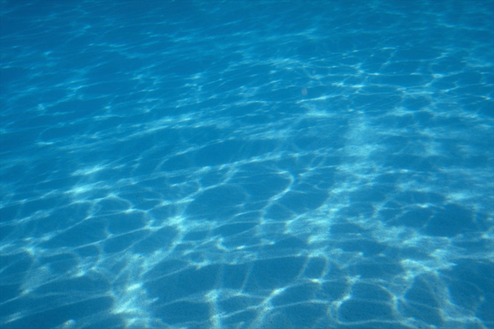 IMAGE_これは透明な水中の写真です。水面に光が反射して、波紋や模様が見えています。おそらく海やプールの水の様子を捉えたものと思われます。