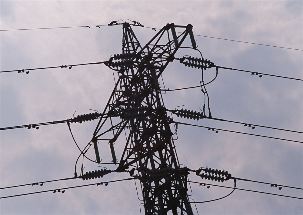 IMAGE_これは電柱の写真です。電力の送電線とその支持構造が映っています。空は曇っているようで、電柱がシルエットとして際立っています。