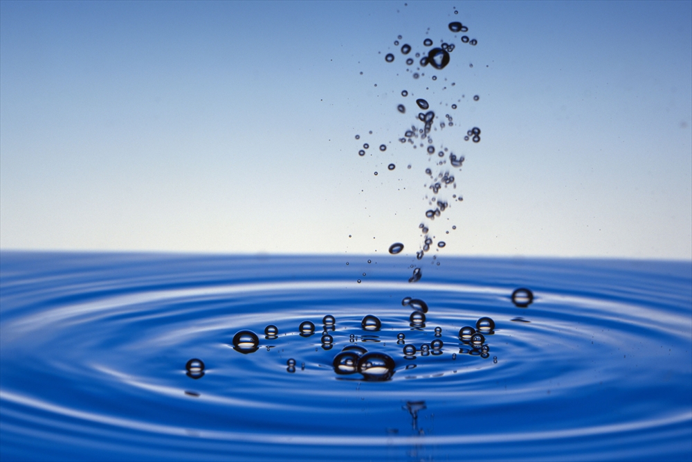 IMAGE_この写真は、水の表面に気泡が浮かんでいる様子を捉えたものです。水の波紋や空の色も見え、全体的に清涼感のある印象を与えます。