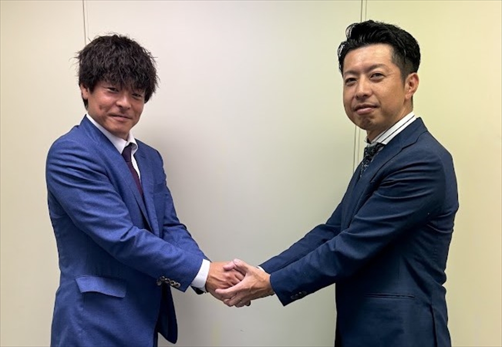 握手する上村会長（左）と海野前会長