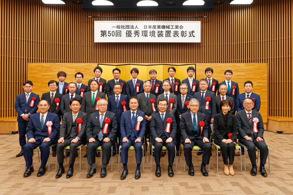 記念撮影に応じる金花産機工会長（前列左から４人目）と受賞者（開発者を含む）