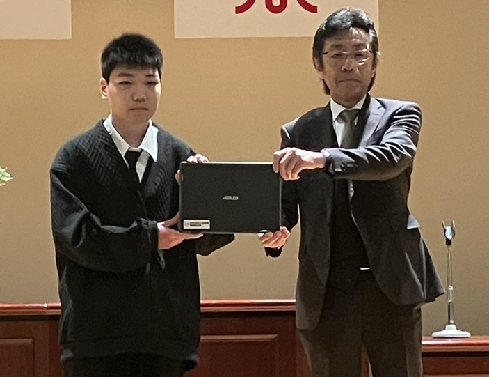 土木学ぶ定時制高生にデジタル端末授与 日本SPR工法協会ら_生徒代表と記念撮影に応じる小原氏(右)