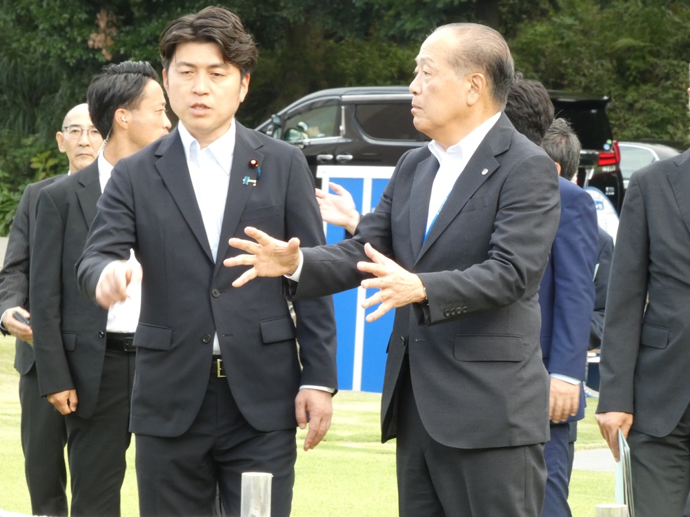 長谷川社長（右）の説明を受けながらセンターを視察する中野国交相