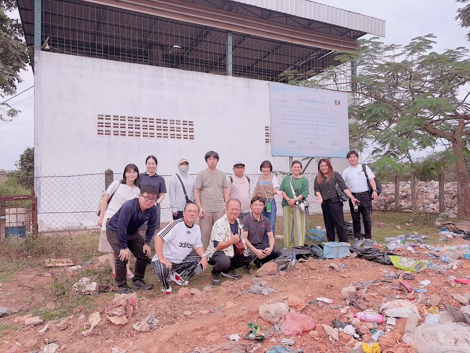 処分場のそばに設置された焼却炉の前に並ぶ視察メンバー