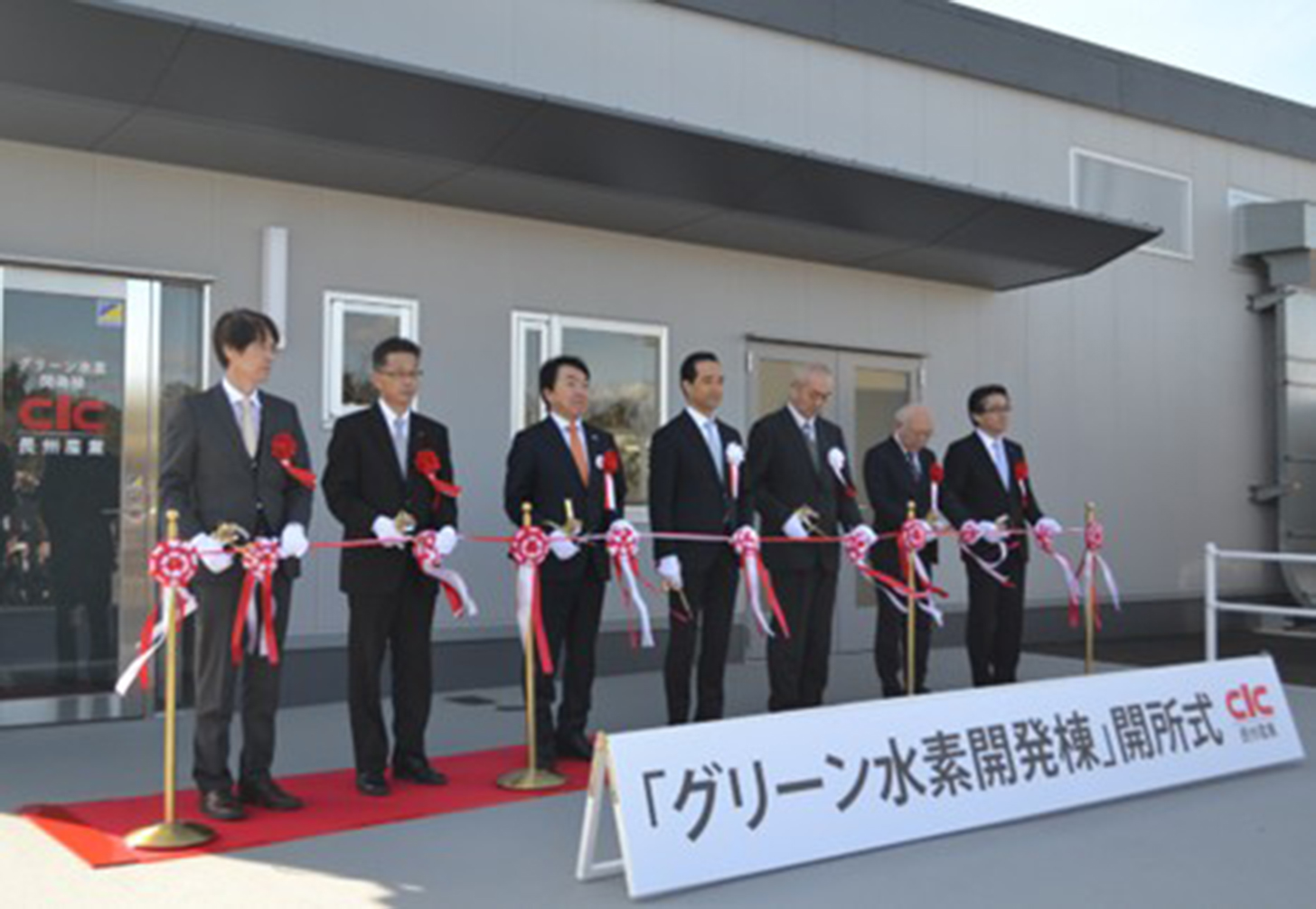 テープカットの様子(左から山口県産業技術センター小関理事長、山口県永田部長、藤田山陽小野田市長、長州産業・岡本社長、同・倉田本部長、大本組・青木取締役専務執行役員、堀場製作所・森ジュニアコーポレートオ_　