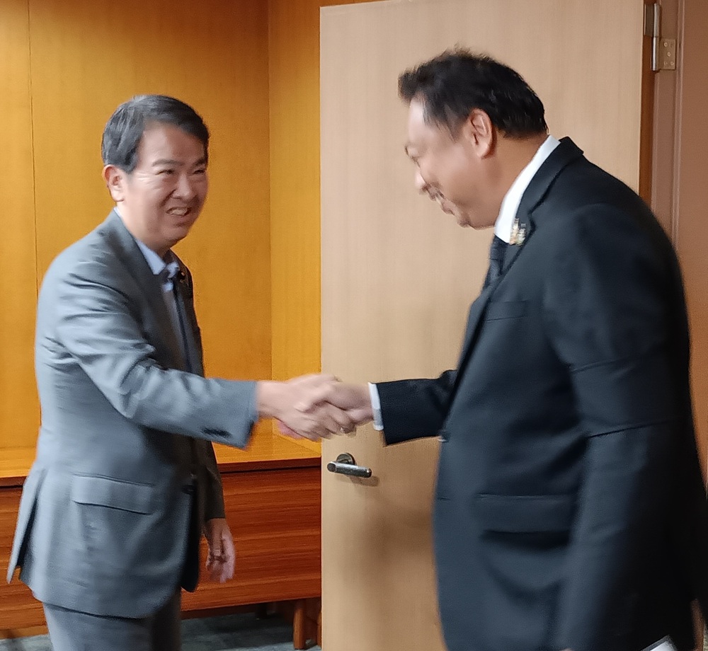石原環境相（左）と握手するチョムクリン環境相
